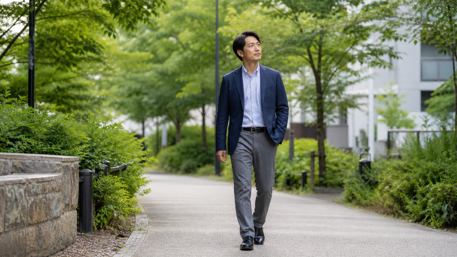 緑の多い公園をゆっくり歩き、仕事から離れて回復時間を確保する会社員